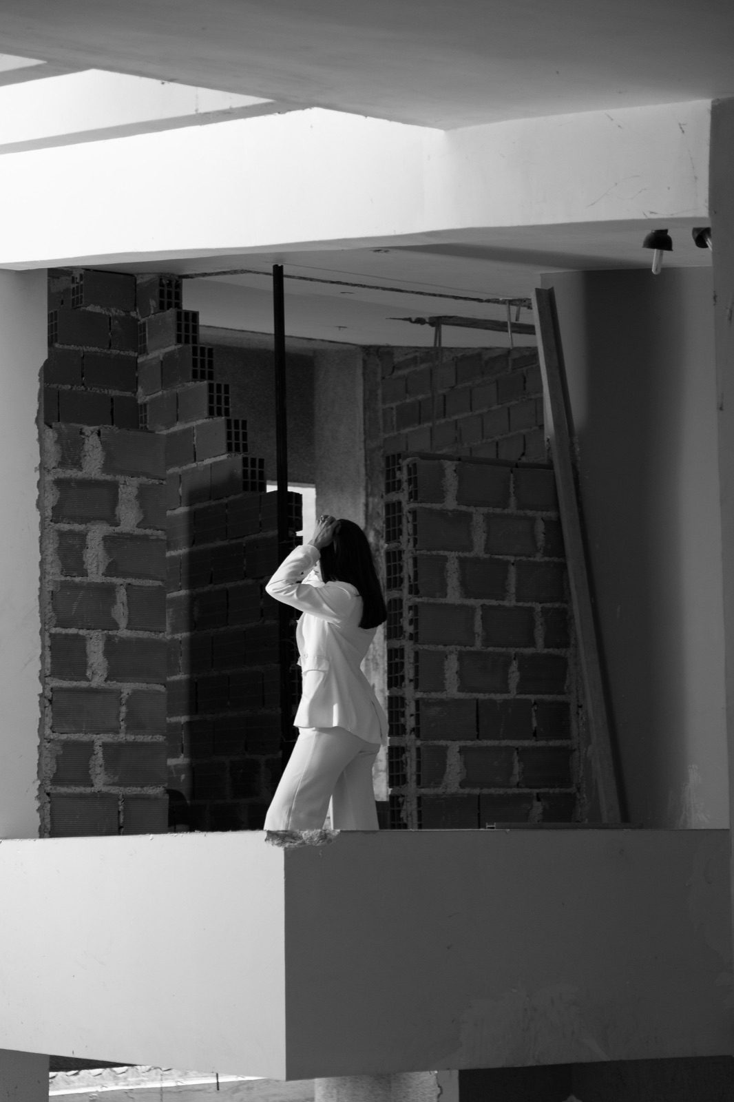 Andrea Domínguez dentro de una obra en construcción, paredes de ladrillo y estructura visible.